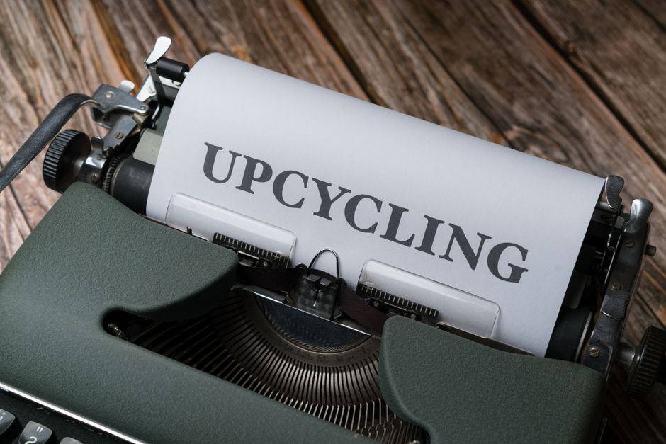 Close-up of a vintage typewriter showing a sheet with 'Upcycling' on it, promoting sustainability.