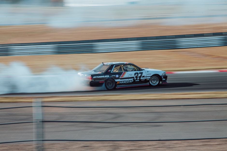 Racing car drifting with smoke on a Moscow speedway, showcasing speed and agility.