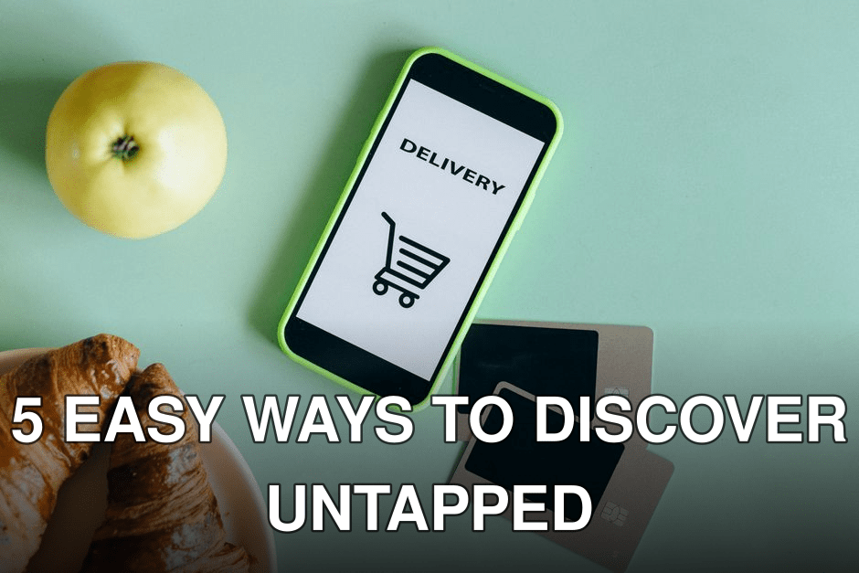 A smartphone with a delivery app next to an apple, croissants, and credit cards on a green surface.