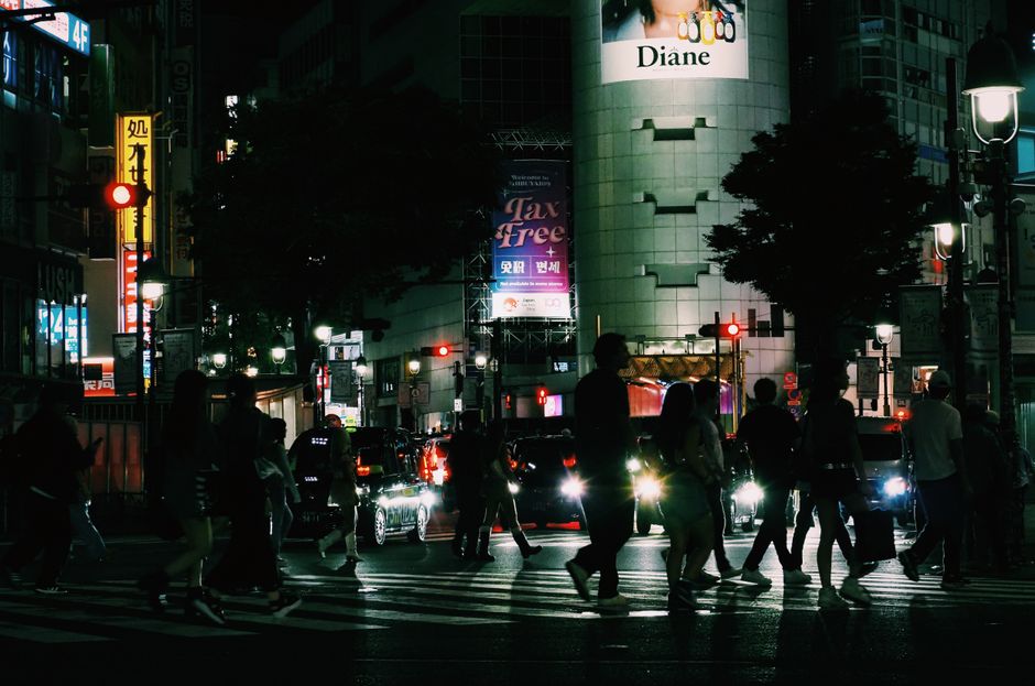 Dynamic evening view of people crossing Shibuya in Tokyo, showcasing urban nightlife.