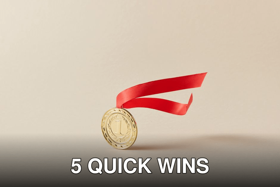 Close-up of a gold medal with a red ribbon against a neutral background.