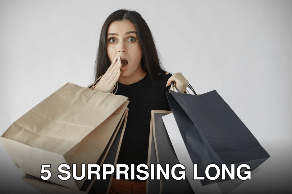 Woman shocked with shopping haul, holding multiple paper bags indoors.