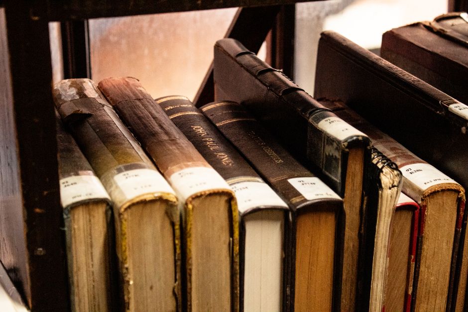 Discover a collection of classic, vintage books on a wooden bookshelf, perfect for book lovers and academics.