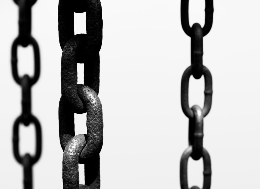 Artistic black and white photo of hanging chains, focusing on texture and connection.