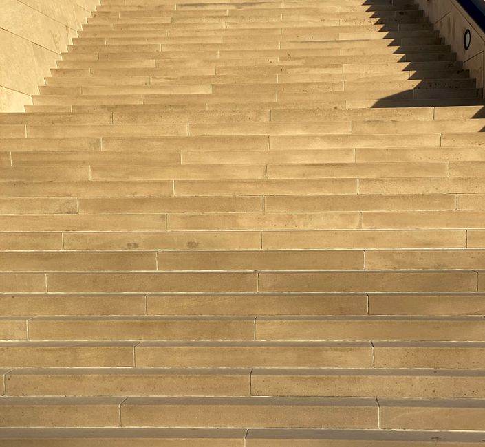 From below of wide empty stone stairway on city street on sunny day