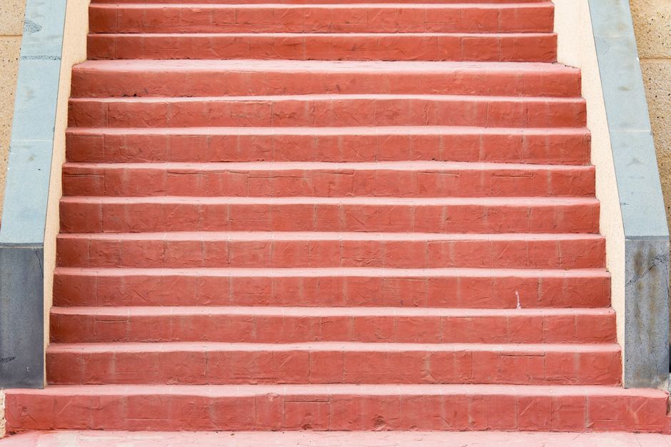 A simple red concrete staircase photographed from the front, offering a minimalist perspective.