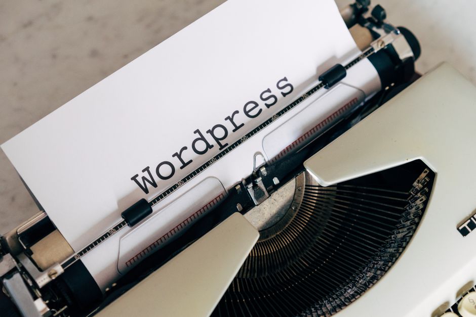 Close-up of a vintage typewriter with a paper displaying 'WordPress', ideal for blogging and writing concepts.