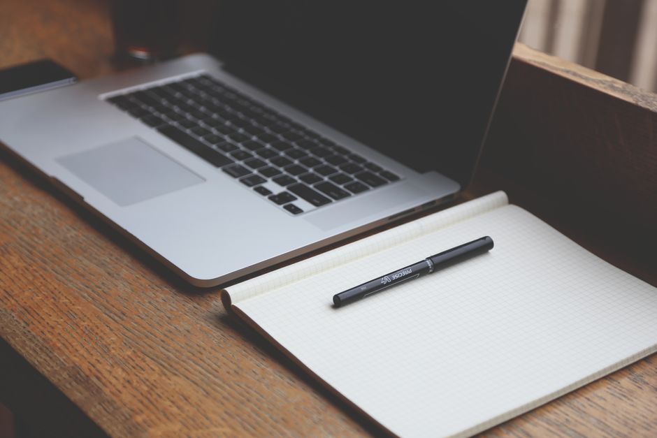 A clean office workspace with a laptop and notebook, perfect for productivity.