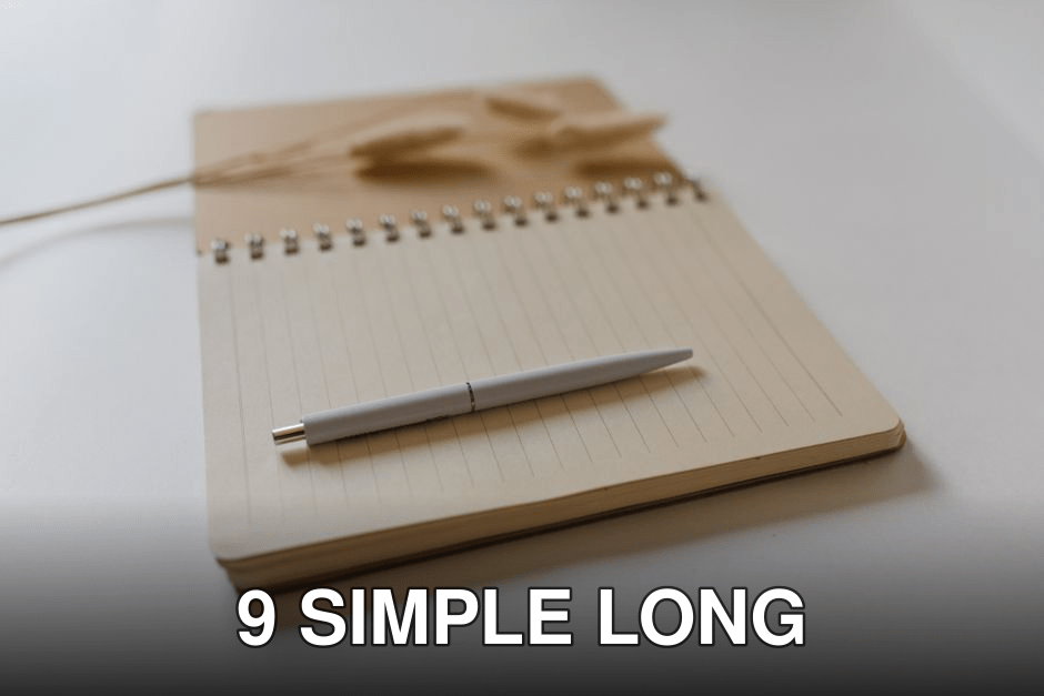 Open lined notebook with a pen and bunny tail grass on a plain surface.