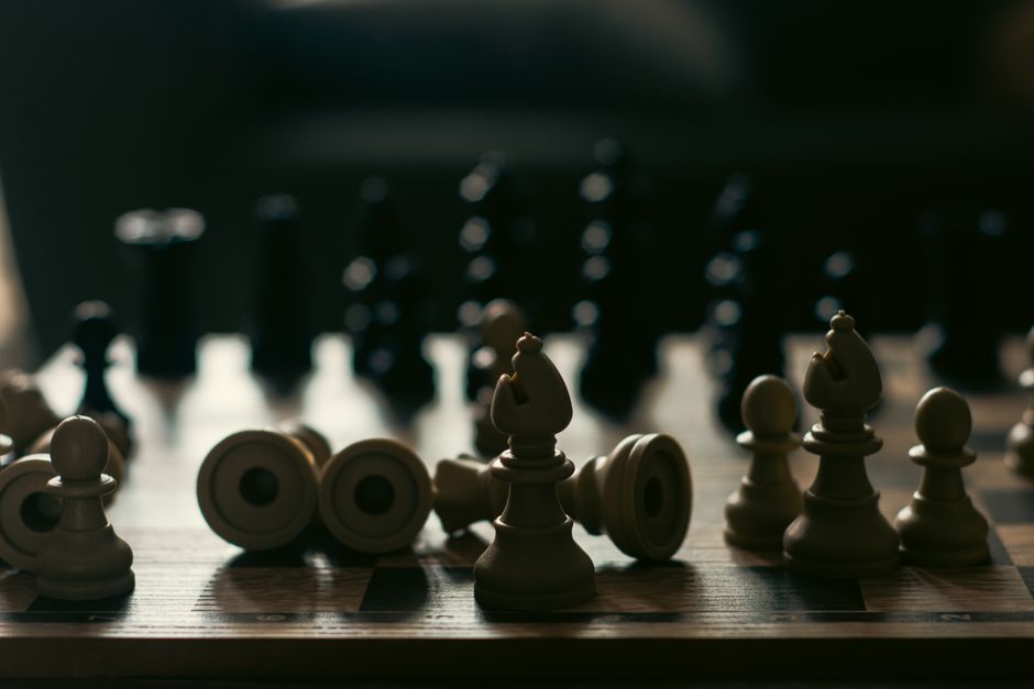 A dramatic representation of strategy and competition with chess pieces on a board.