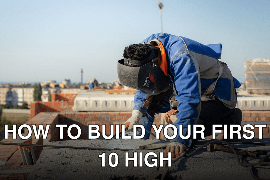 Focused welder in protective gear welding on a city rooftop construction site.