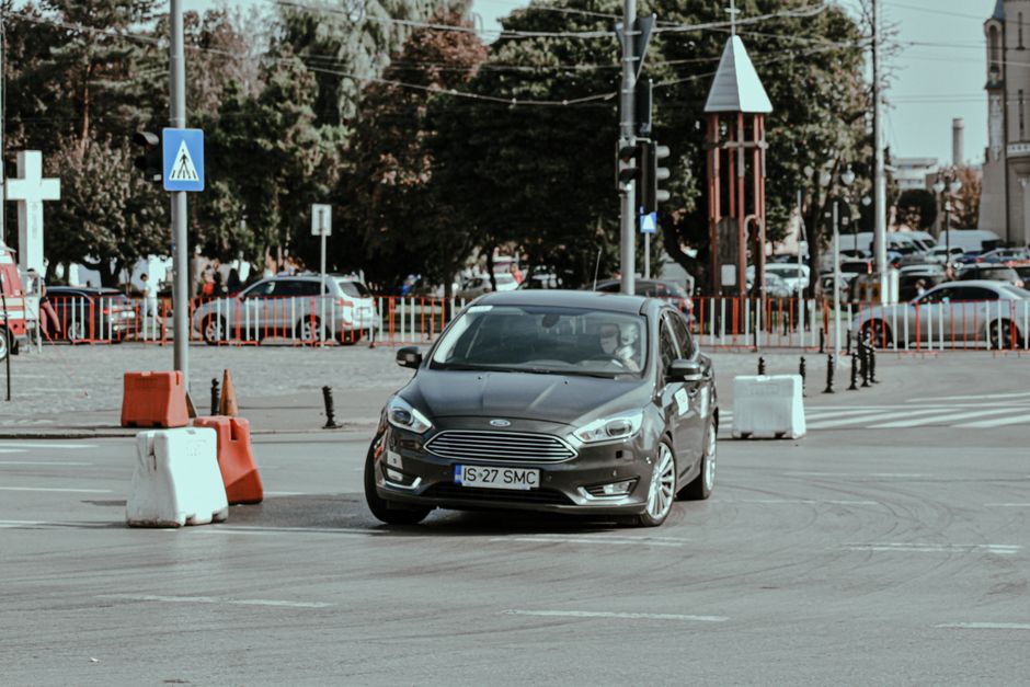 Rally racing car driving fast while turning on asphalt roadway in modern city