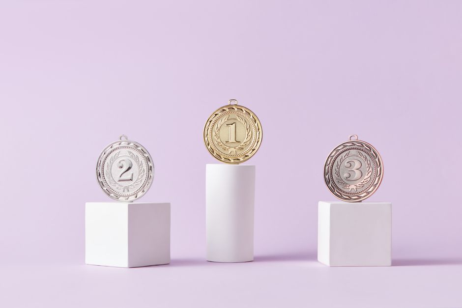 Medals on a podium against a soft pastel background, ideal for awards themes.