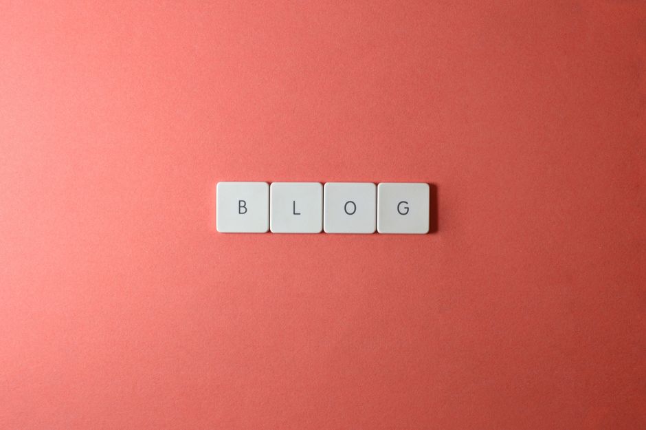 A minimalist image of keyboard keys spelling 'BLOG' on a coral background.