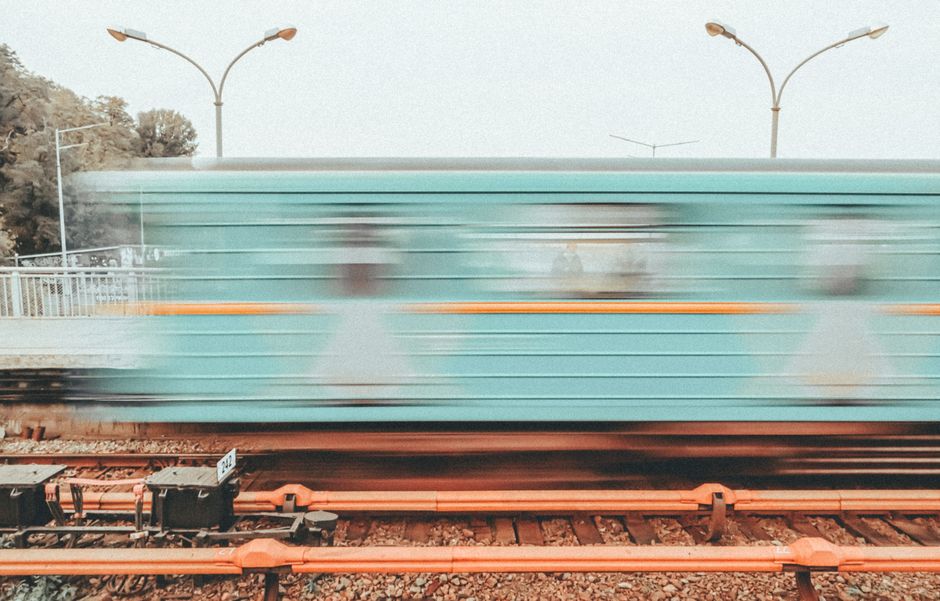 A fast-moving urban train captured in motion on a railway platform.