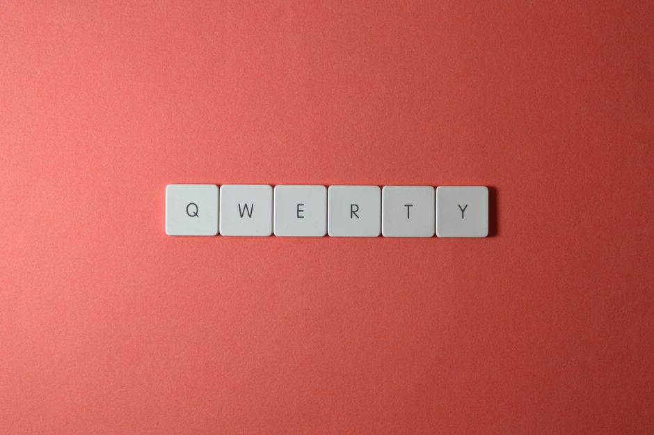 Minimalist display of QWERTY keys arranged on a vibrant red surface, ideal for technology and design concepts.