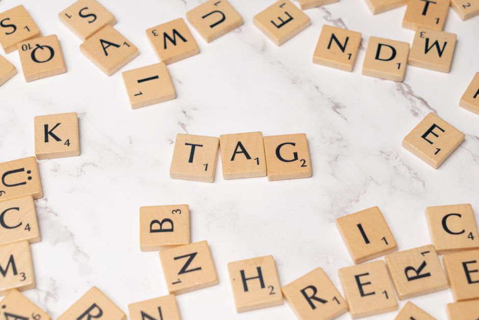 Stylish Scrabble tiles forming 'TAG' on a marble surface for creative projects.