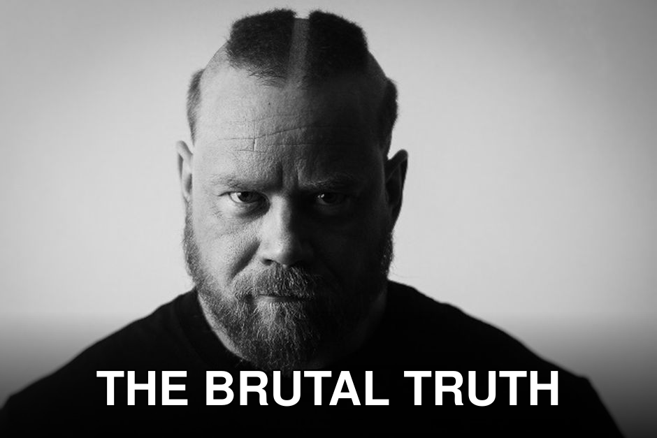 Black and white photo of a bearded man with a fierce expression, showcasing strong masculinity.