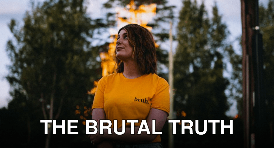 A woman in a yellow shirt stands outdoors at twilight, surrounded by trees and soft lighting.