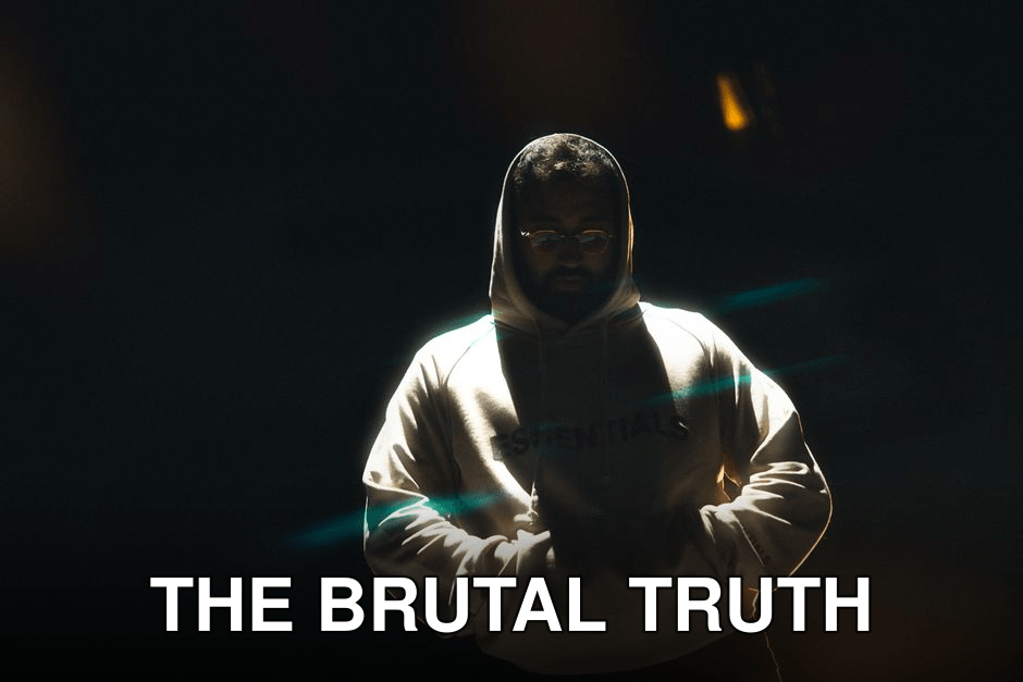 A man wearing a hoodie stands in dramatic lighting at night, hands in pockets, conveying a mysterious mood.