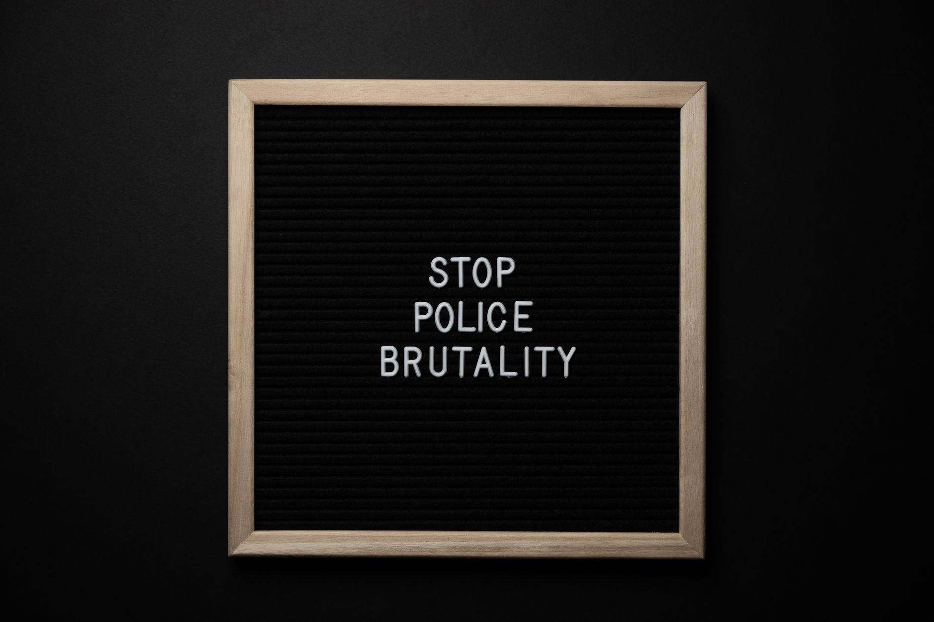 Overhead view wooden frame with white inscription about social injustice on black background
