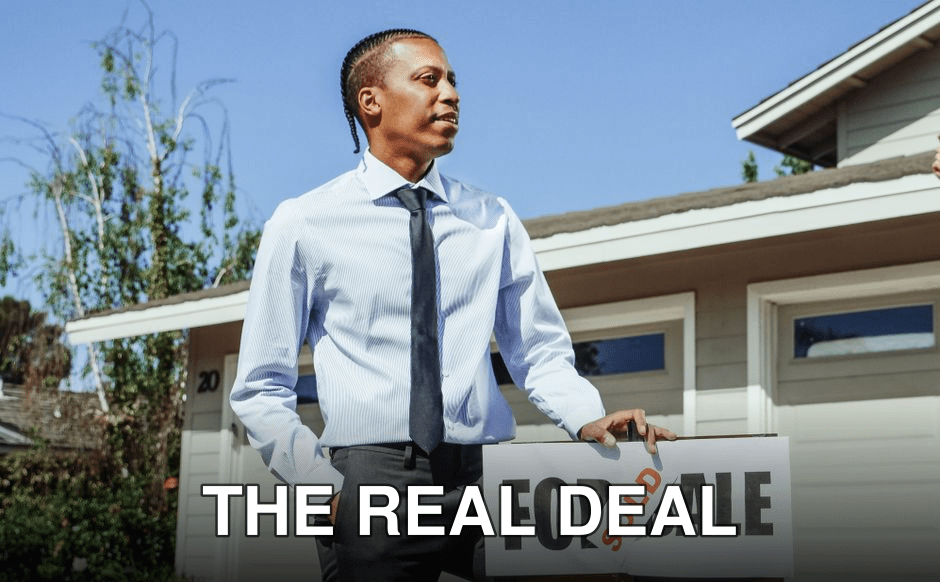 Real estate agent presenting a sold sign in front of a residential property.