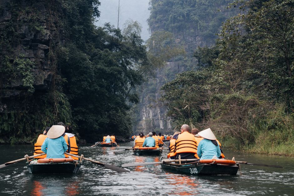 Experience the serene beauty of Ninh Binh, Vietnam with a peaceful boat tour through lush landscapes.