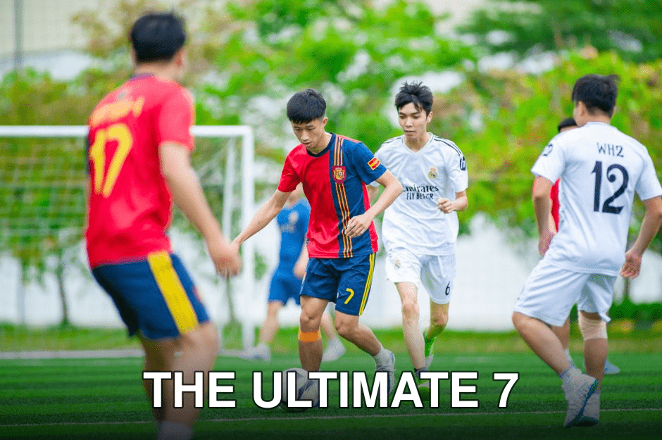 Young players engaged in a soccer match on a vibrant green field in Hanoi.