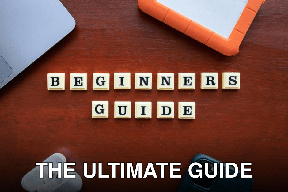 Creative flat lay of gadgets and 'Beginners Guide' text on wooden table.