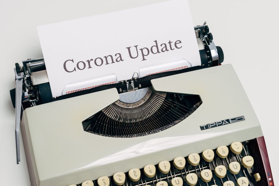 A vintage typewriter displaying a page with the words 'Corona Update' typed on it.