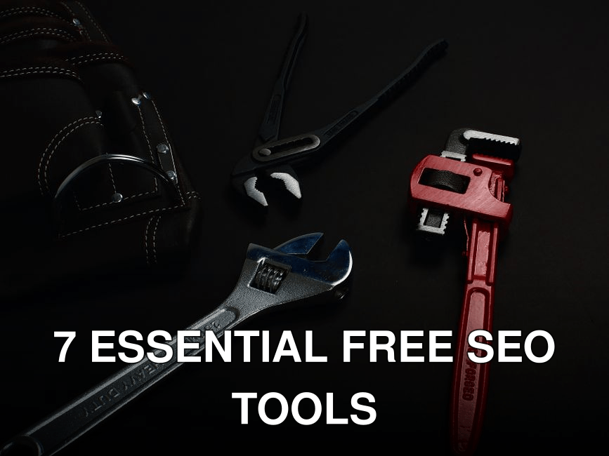 Close-up of various hand tools including wrenches and pliers on a dark surface.