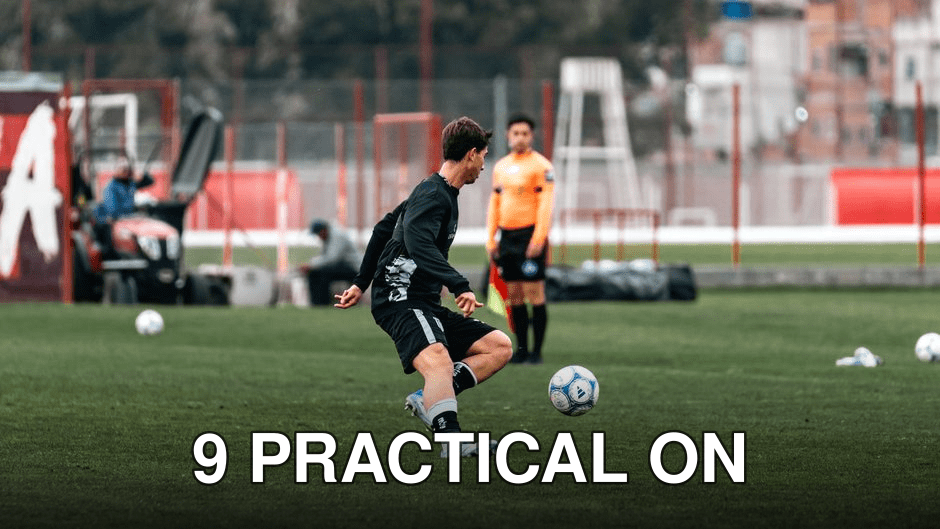 Soccer player controlling ball during outdoor training with referee in background.