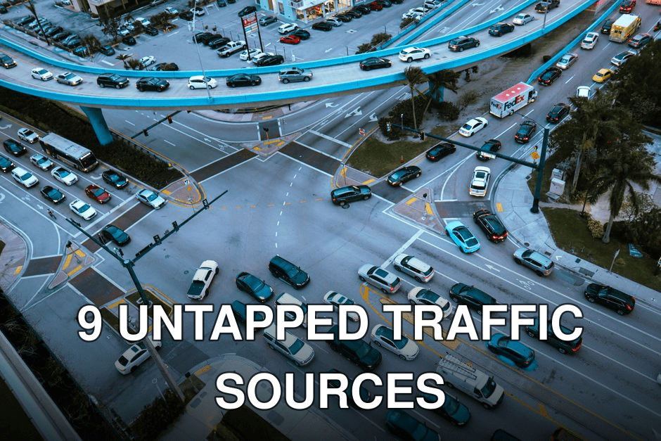 Aerial view of a busy urban intersection filled with cars and traffic under a blue overpass.